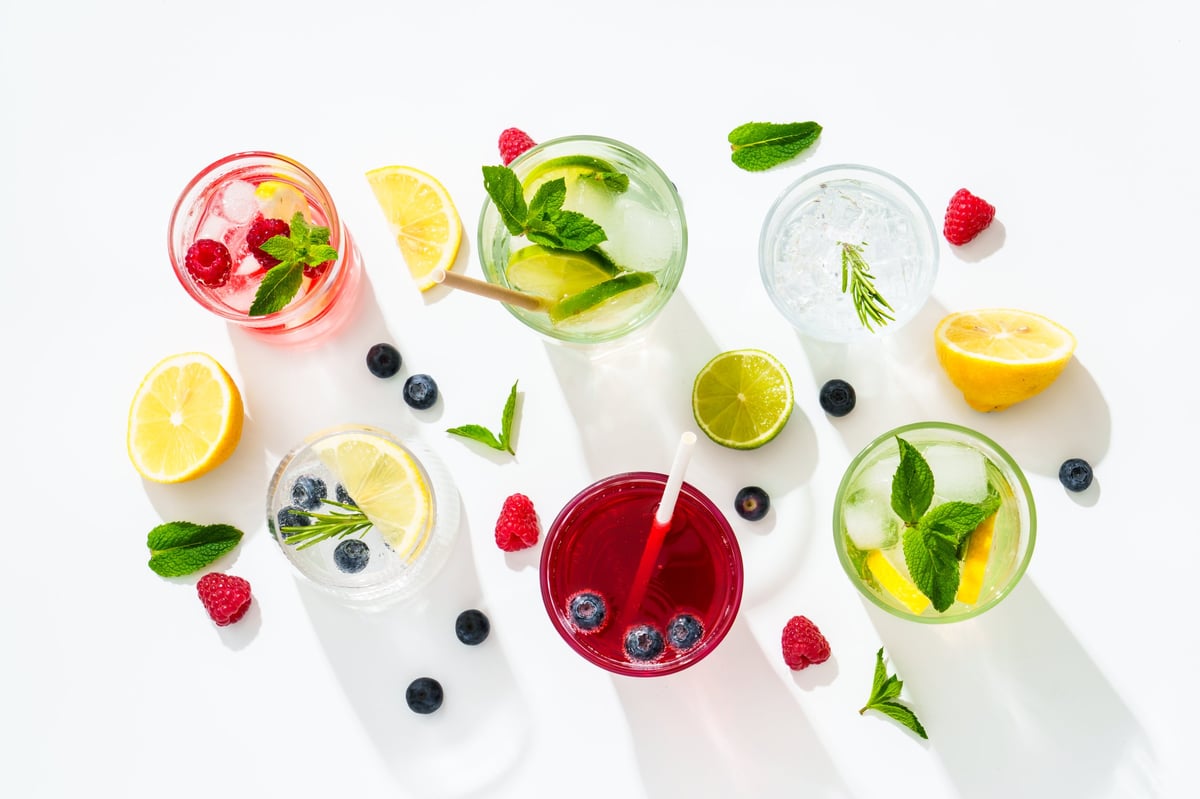 Summer drinks, colored cocktails on white background with fresh fruits