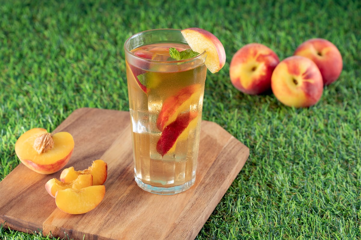 Refreshing peach iced tea with fresh fruit pieces in a glass
